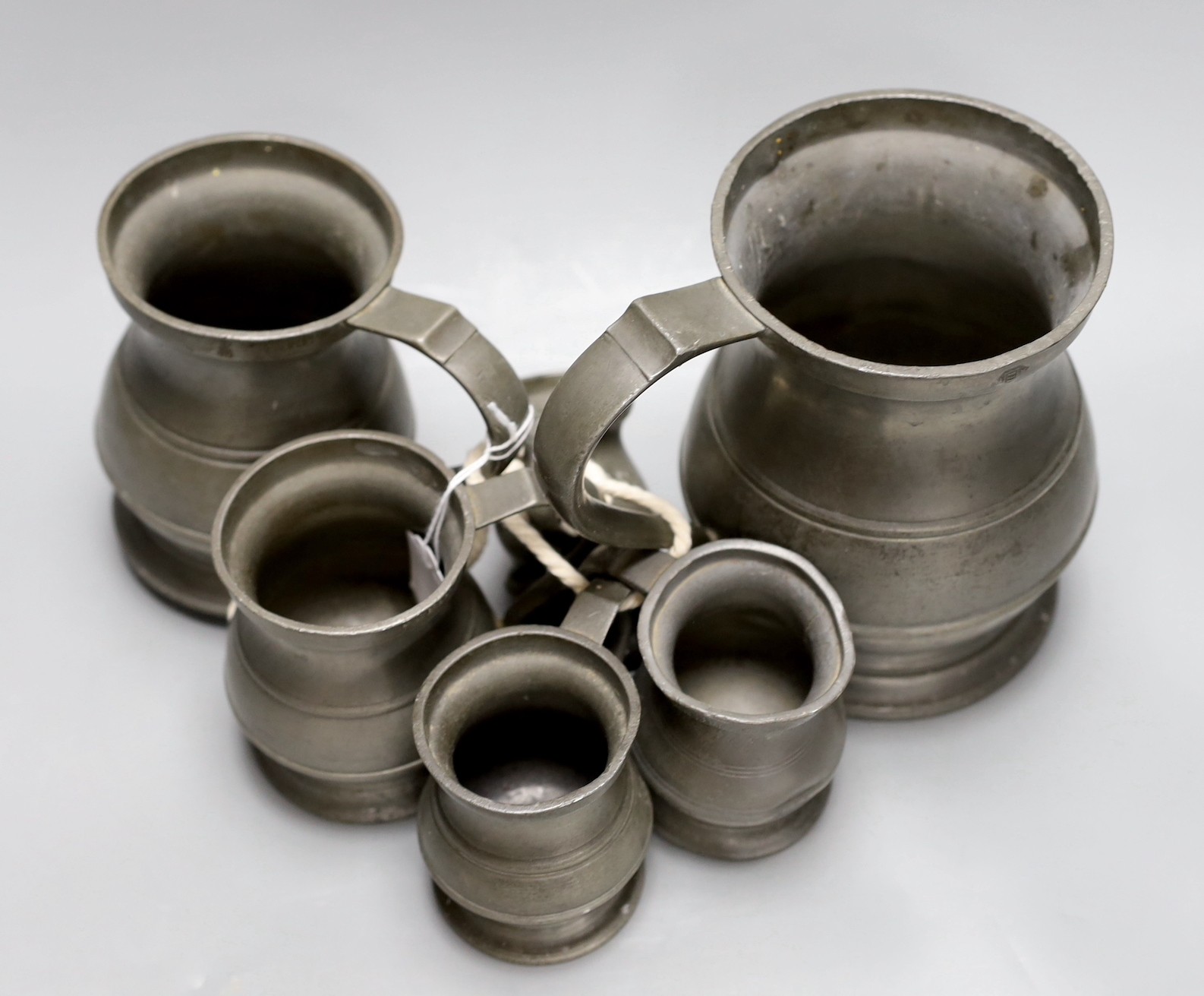 A set of six graduated pewter tankards, tallest 16 cms high